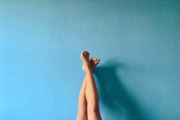 woman's knees on blue background