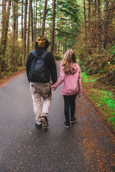 Man and girl walking backward on a trail